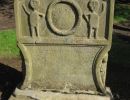 Torphican churchyard - 'Adam and Eve' carving carries over onto the edges of the stone.